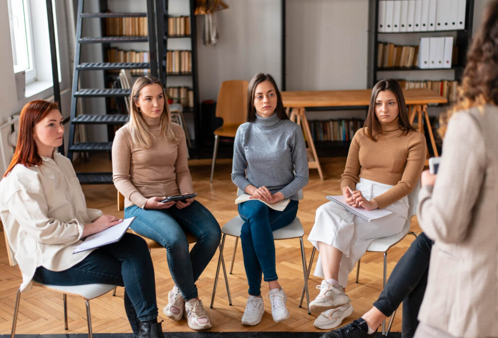 Young adults sitting in a circle at a group therapy session