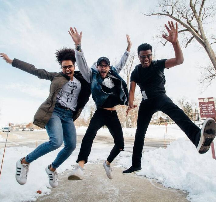 Young adults jumping with joy.