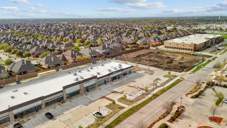 Aerial view of buildings, parking lots, and surrounding neighborhood