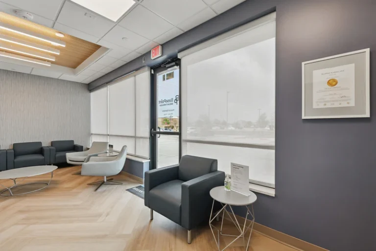Entryway seating area with chairs, tables, and large windows