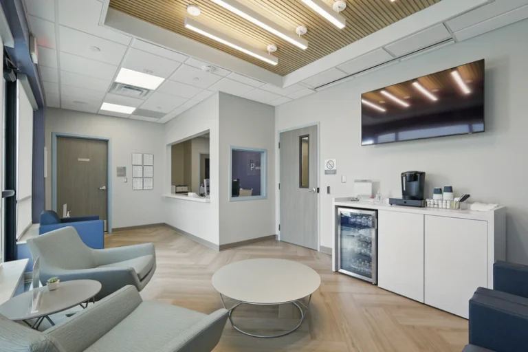 Reception and waiting area with seating, coffee station, and television