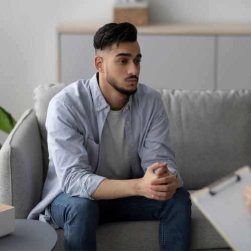 Young man listening while a therapist takes notes