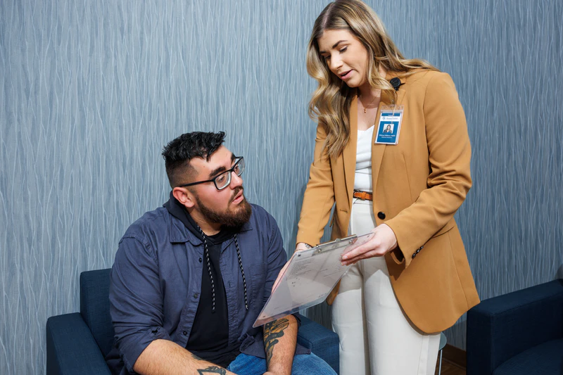 Credentialed BasePoint BreakThrough worker showing a man his mental health testing results