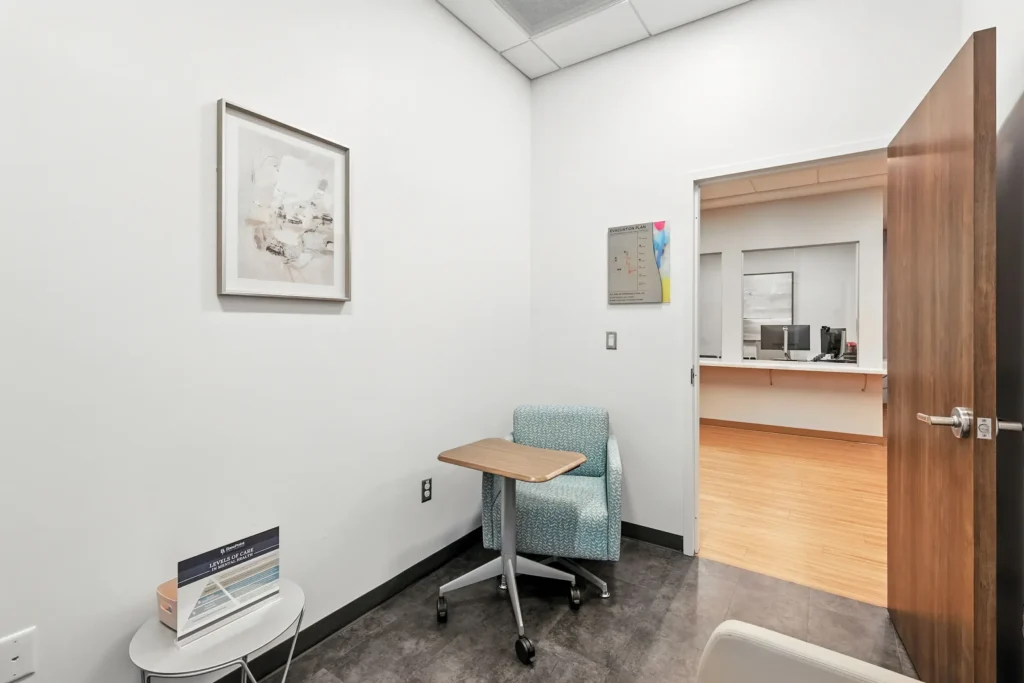 Small private consultation room with chair and tablet desk