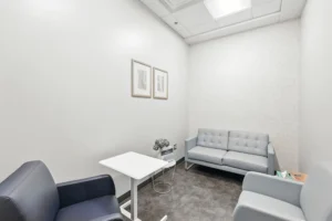 Minimalist therapy room with gray furniture.