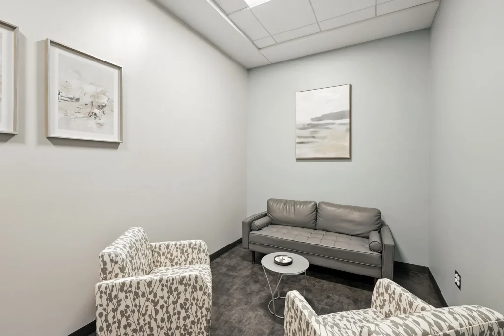 Small consultation room with sofa, chairs, and side table