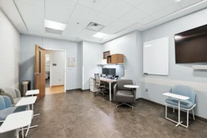 Group room with seating, whiteboard, and wall-mounted screen