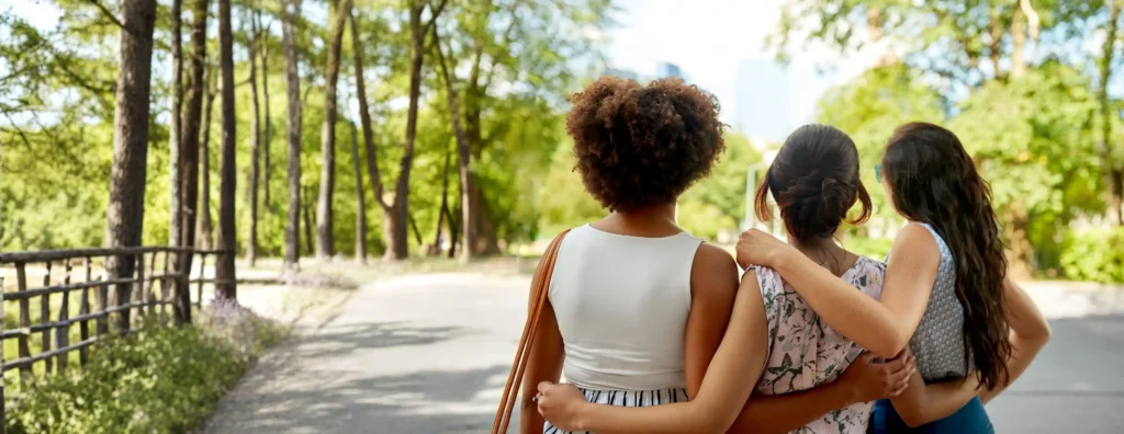 Three friends walking together outdoors