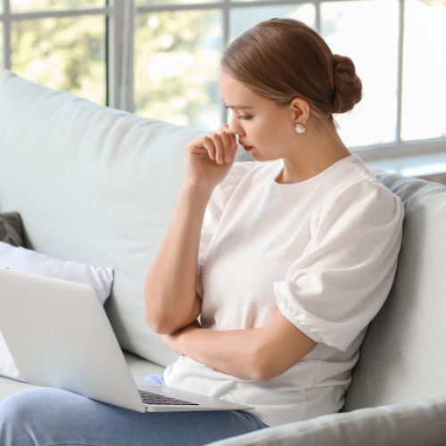 A distressed young woman during an online mental health therapy session