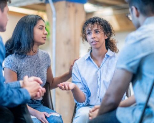Young woman talking during group therapy